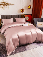 Peach skin 19 Momme mulberry silk duvet cover set with two pillowcases on a bed.