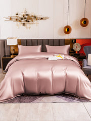 Pink 19Momme mulberry silk duvet cover set with two pillowcases on a bed.