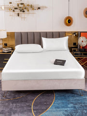White 19 Momme mulberry silk fitted sheet and two pillowcases on a bed.