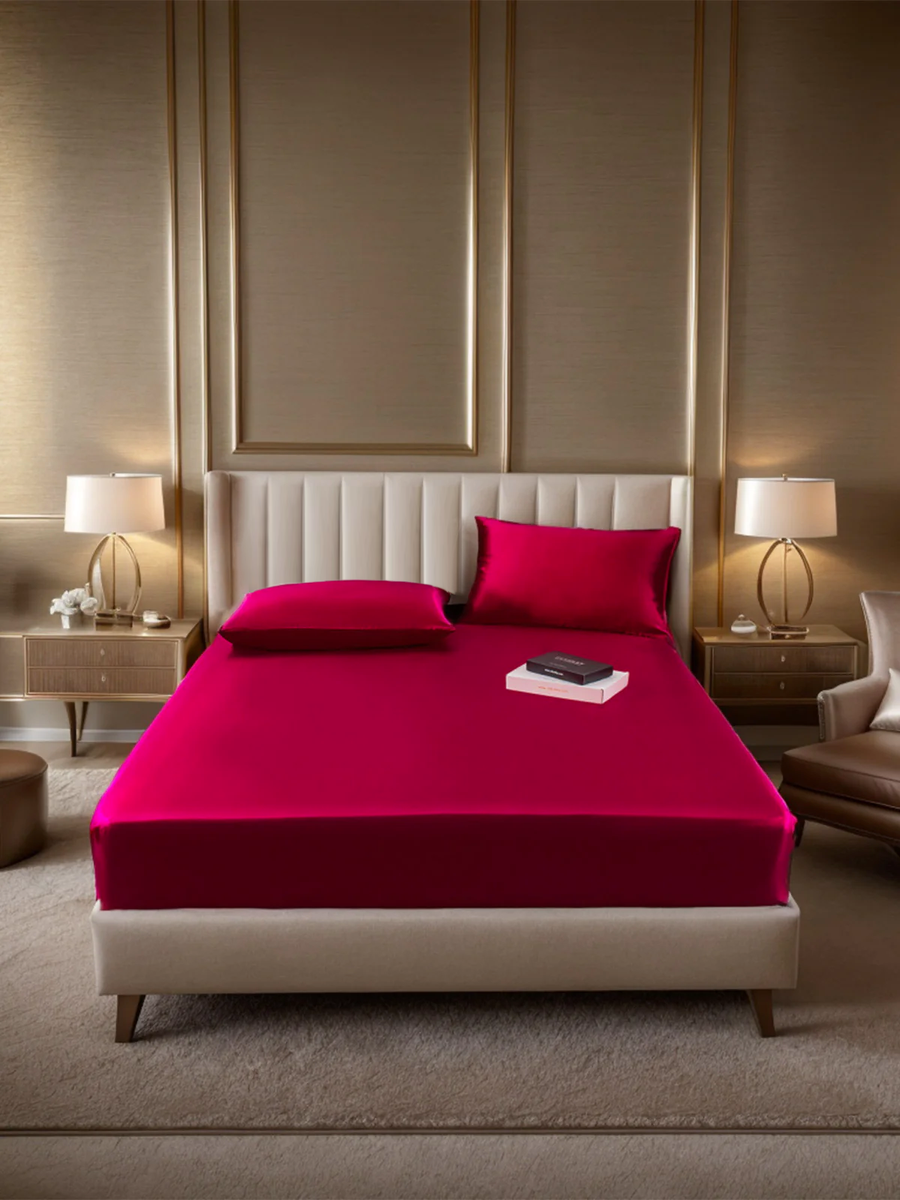 Luxurious Marberry 19 Momme silk fitted sheet and two pillowcases in vibrant fuchsia on a modern bed.