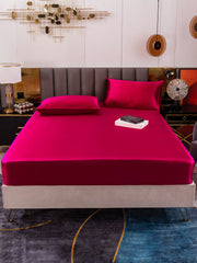 Vibrant mulberry silk fitted sheet and two pillowcases in a rich fuchsia color, styled on a bed.