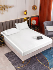 White 19 Momme mulberry silk fitted sheet set with two pillowcases on a bed.