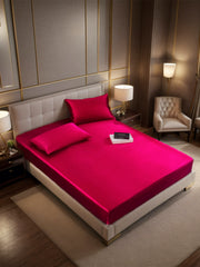 Wine red 19 Momme mulberry silk fitted sheet and two pillowcases on a bed.