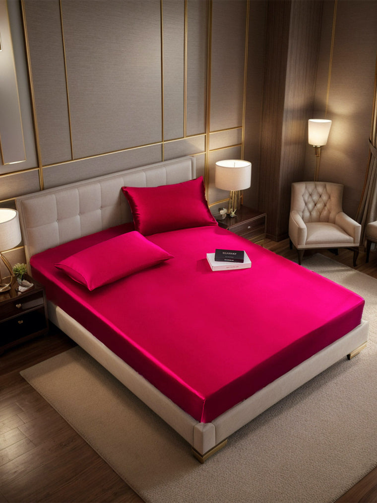 Wine red 19 Momme mulberry silk fitted sheet and two pillowcases on a bed.