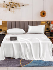 White 19 Momme mulberry silk flat sheet and two pillowcases on a bed.