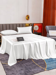White 19 Momme mulberry silk flat sheet and two pillowcases set on a bed.