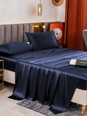 Navy blue 19 Momme mulberry silk bedding set with fitted sheet, flat sheet, and two pillowcases.