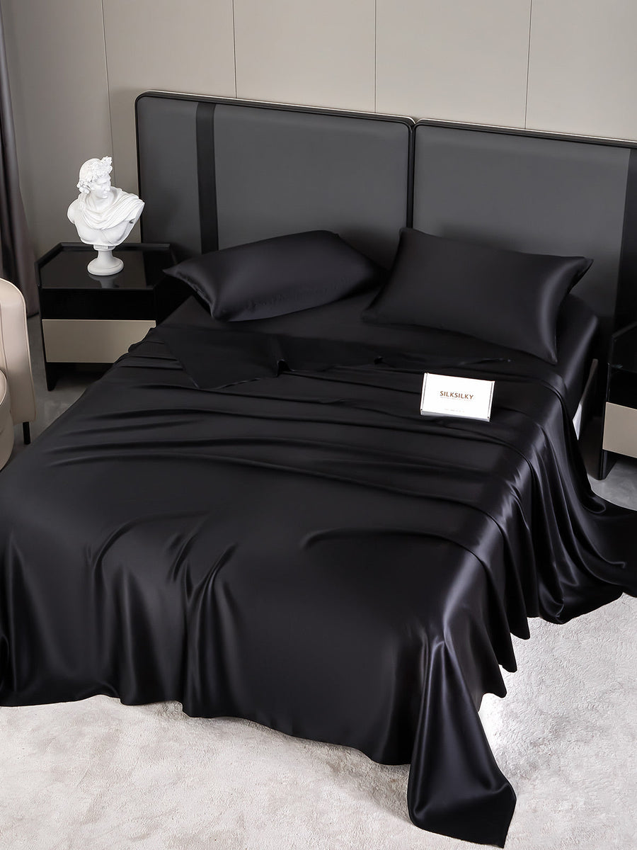 Luxurious black 19 Momme mulberry silk bedding set with fitted sheet, flat sheet, and two pillowcases.