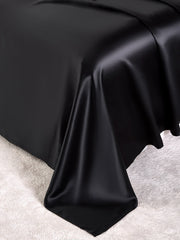 Smooth black 19 Momme mulberry silk bedding set, including flat sheet, fitted sheet, and pillowcases.