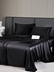 Luxurious black 19 Momme mulberry silk bedding set with fitted sheet, flat sheet, and two pillowcases.