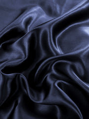 Wrinkled navy blue mulberry silk fabric, 19 Momme, showing luxurious sheen and soft texture.