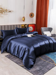 Navy blue 19Momme mulberry silk duvet cover set with fitted sheet and two pillowcases on a bed.