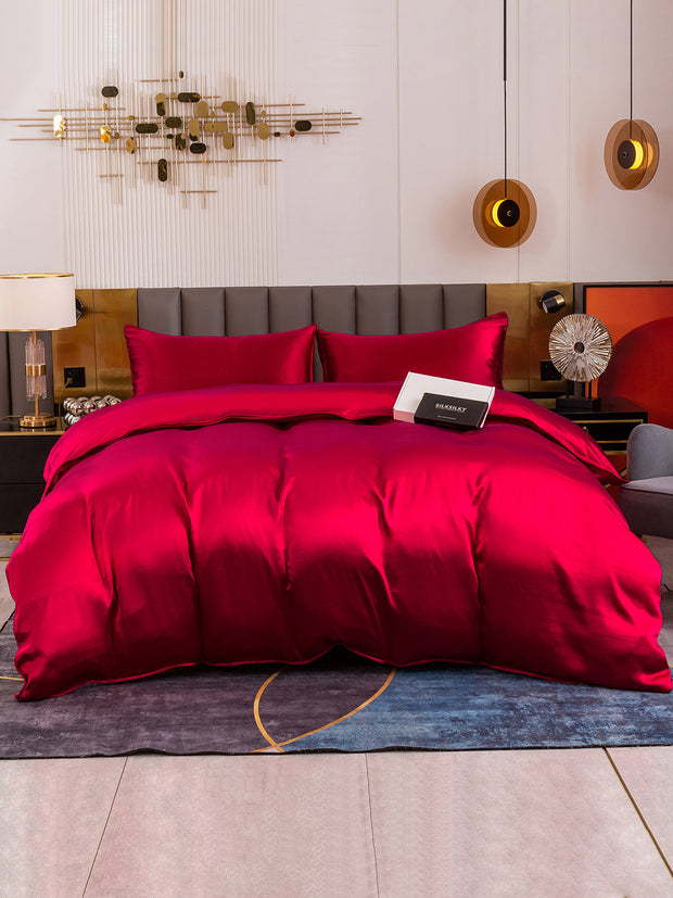 Luxurious red 19 Momme mulberry silk 4-piece bedding set with duvet cover, fitted sheet, and two pillowcases.