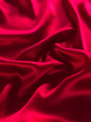 Luxurious deep red mulberry silk fabric with elegant drapes and a soft sheen, perfect for bedding.