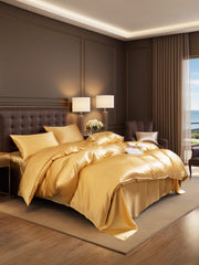 Luxurious gold 19 Momme mulberry silk 4-piece bedding set with duvet cover, flat sheet, and two pillowcases.