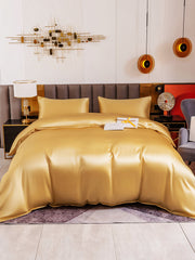 Luxurious gold 19Momme mulberry silk 4-piece bedding set with duvet cover, flat sheet, and two pillowcases.