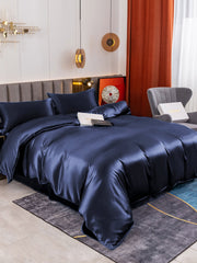 Luxurious navy blue 19 Momme mulberry silk duvet cover set with flat sheet and two pillowcases on a bed.