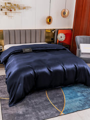 Navy blue 19 Momme Mulberry silk seamless duvet cover on a bed, showcasing its luxurious sheen.