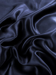 Wrinkled dark blue 19 Momme Mulberry silk seamless duvet cover fabric with a luxurious sheen.