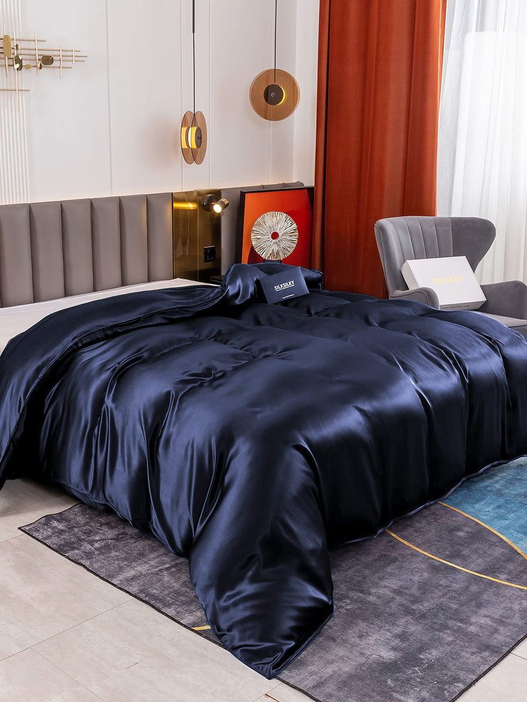 Dark blue 19 Momme Mulberry silk seamless duvet cover on a bed.