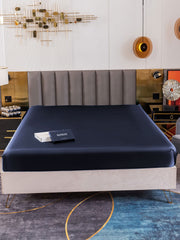 Navy 19 Momme Mulberry silk seamless fitted sheet on a bed.
