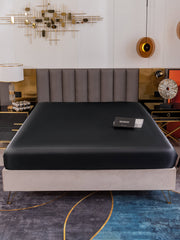 Black 19 Momme Mulberry Silk Seamless Fitted Sheet on a bed, showcasing its smooth, luxurious texture.