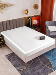 White 19Momme Mulberry Silk Seamless Fitted Sheet on a bed, showcasing its smooth, luxurious texture.