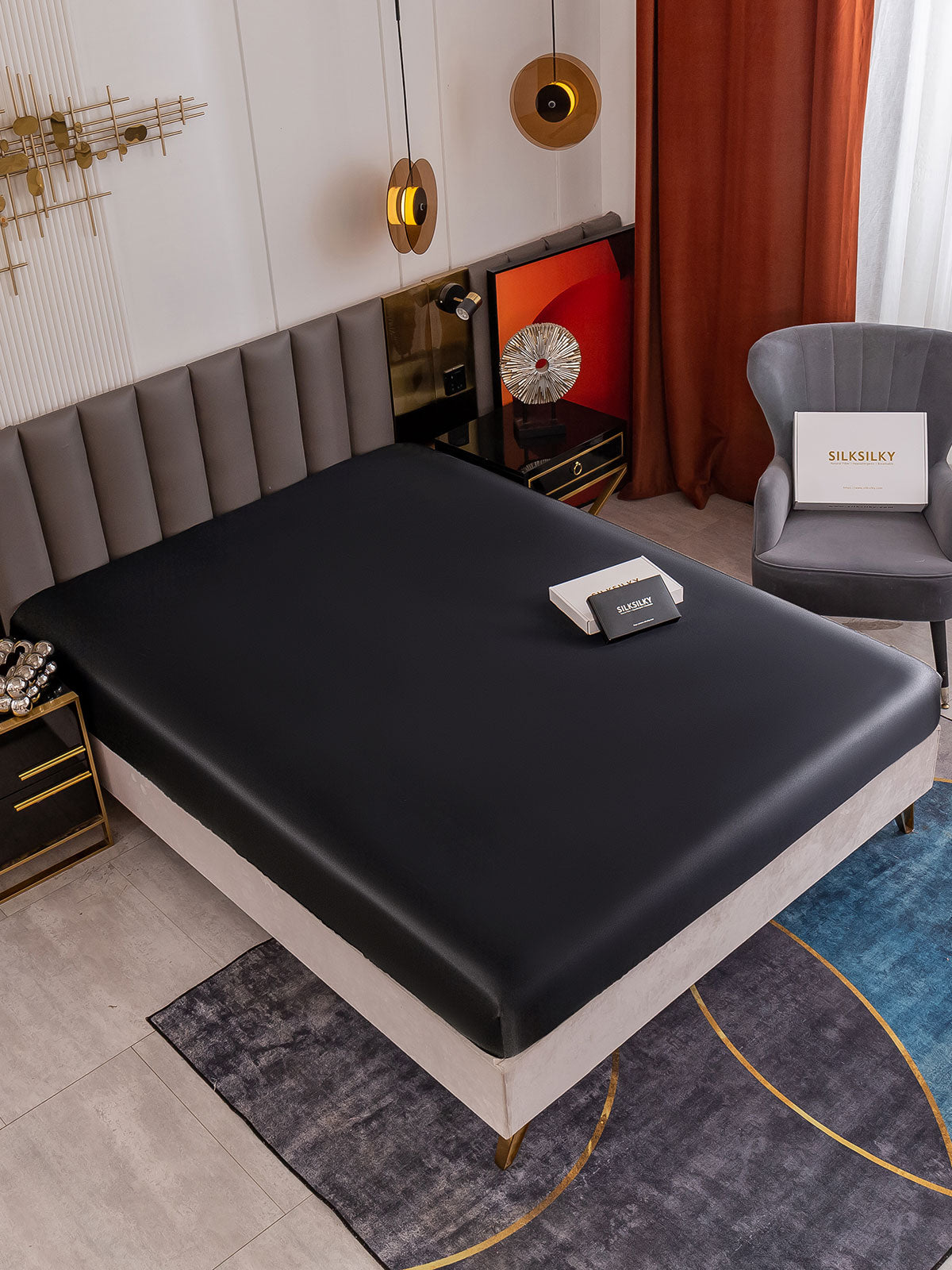 Black 19Momme Mulberry Silk Seamless Fitted Sheet on a bed in a modern bedroom setting.