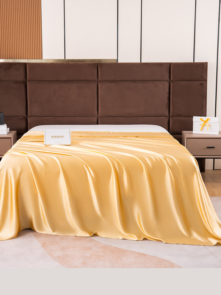 Champagne 19Momme Mulberry Silk Seamless Flat Sheet draped on a bed.