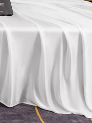 White 19Momme mulberry silk seamless flat sheet draped over a bed, showcasing its smooth, luxurious texture.
