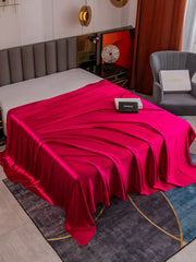 Wine red 19 Momme Mulberry silk seamless flat sheet draped on a bed.