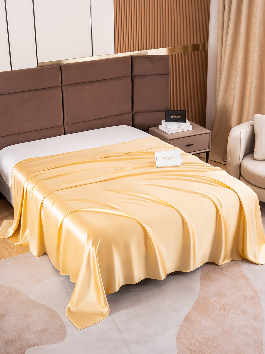 Golden 19Momme Mulberry Silk Seamless Flat Sheet draped on a bed.