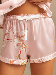 Women's pink mulberry silk pajamas shorts with crane print, elastic waist, and white drawstring.
