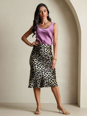 Woman in a mulberry silk leopard print stretch straight long skirt and a lavender silk top.