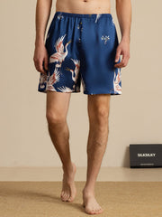 Men's 19 Momme mulberry silk sleep shorts in blue with crane print and elastic waist.
