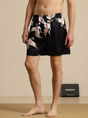 Men's black mulberry silk sleep shorts with white crane print and elastic waist.