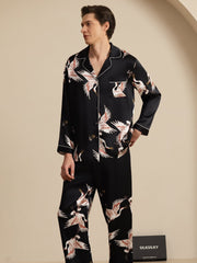 Men's black mulberry silk pajamas with white crane print, long sleeves, and notch collar.