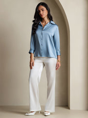 Women's light blue 19Momme mulberry silk 3/4 sleeve lapel collar button-up shirt with white pants.