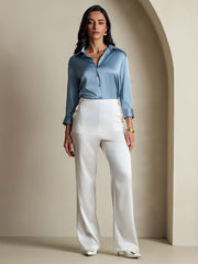 Woman in a blue 19 Momme mulberry silk 3/4 sleeve lapel collar button-up shirt and white wide-leg pants.