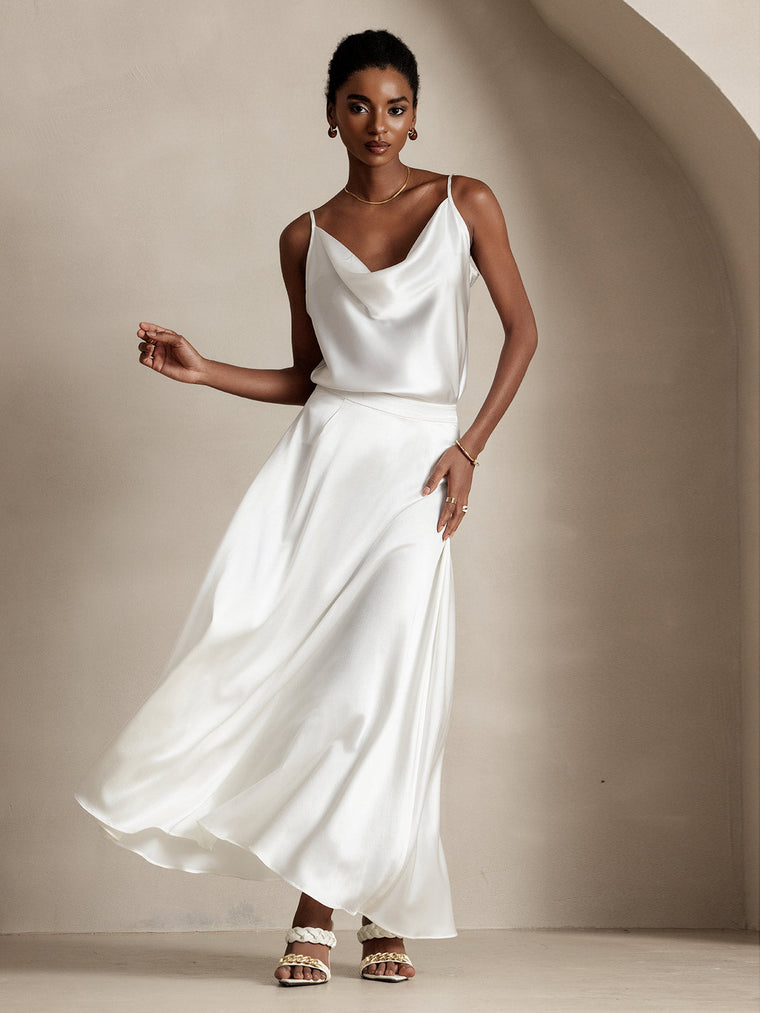 Woman in a flowing white mulberry silk A-line maxi skirt with a matching cowl neck silk top.