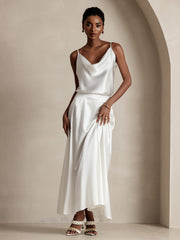Woman in a white 19Momme mulberry silk A-line maxi skirt and matching cowl neck top.