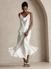 White 19Momme mulberry silk A-line maxi skirt with lining and matching cowl neck camisole on a woman.