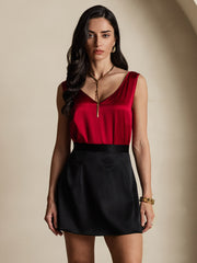 Woman in a red mulberry silk v-neck top and black 19Momme silk A-line mini skirt with zipper design.
