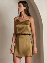 Woman wearing a golden mulberry silk camisole and matching A-line mini skirt.