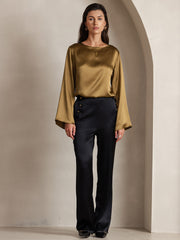 Women's olive green 19 Momme mulberry silk bell sleeve boat neck top with black pants.