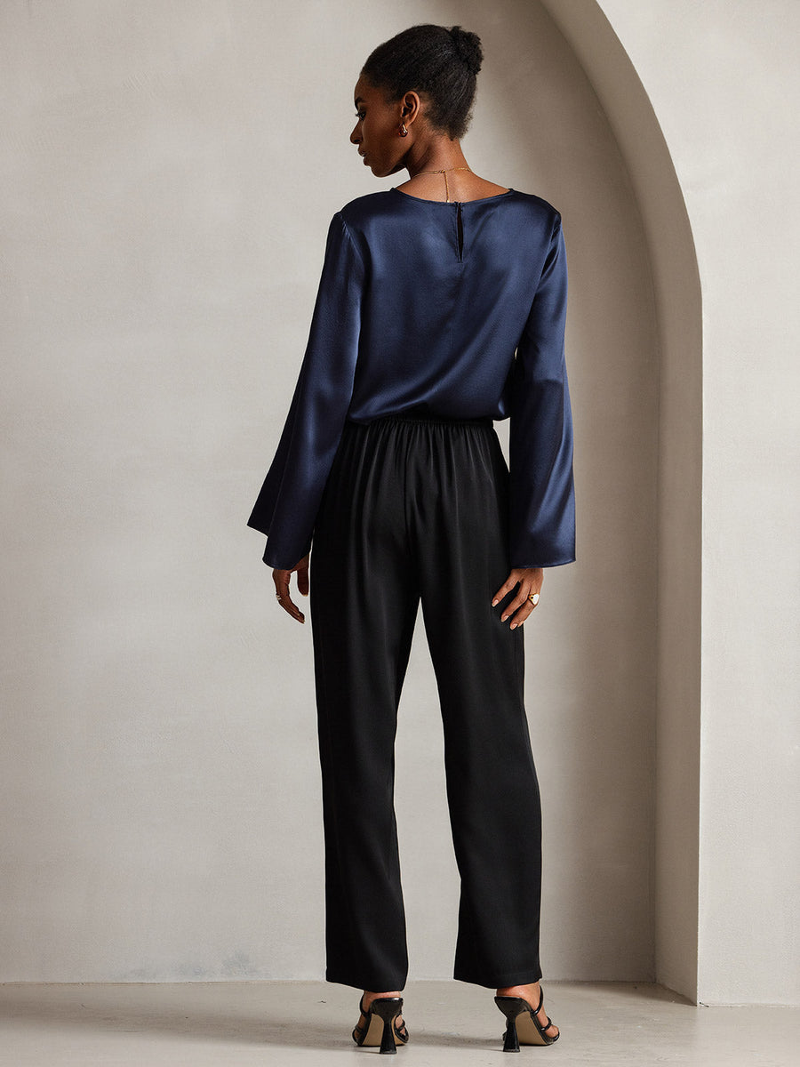Women's navy mulberry silk bell sleeve boat neck top paired with black pants.