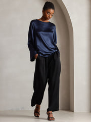 Navy 19 Momme mulberry silk bell sleeve boat neck women's top with black pants.