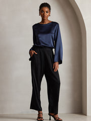 Women's navy 19Momme mulberry silk bell sleeve boat neck top with black pants.