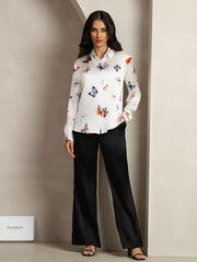 Women's white 19Momme mulberry silk butterfly print long sleeve lapel collar shirt with black pants.