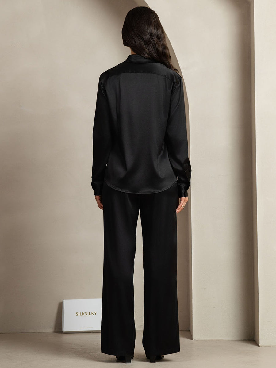 Women's black 19 Momme mulberry silk button-up shirt and wide-leg pants set, seen from behind.